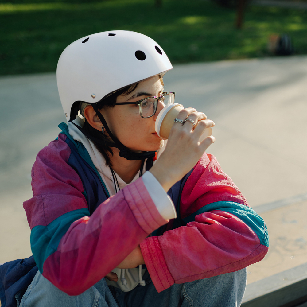 Skateboarder drinking coffee at skatepark after training session
