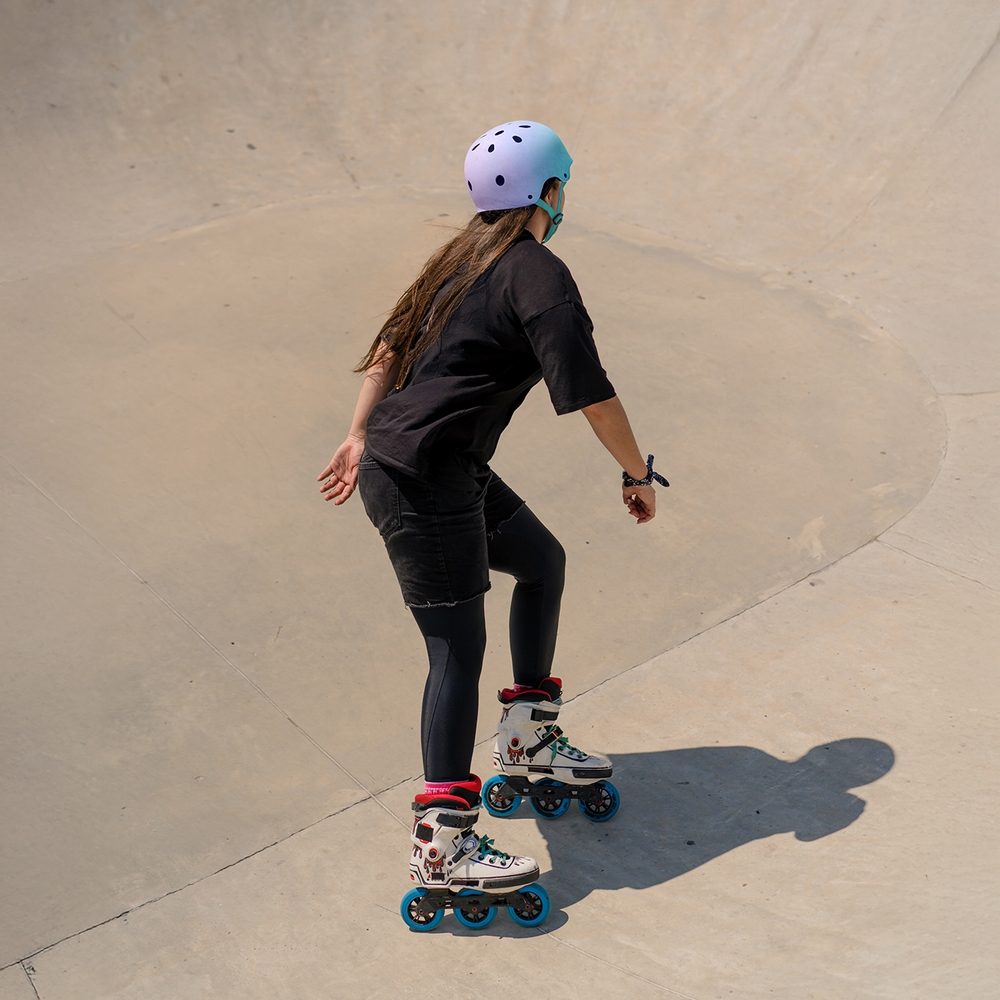 young skilled woman rollerblading and jumping on the ramp in the